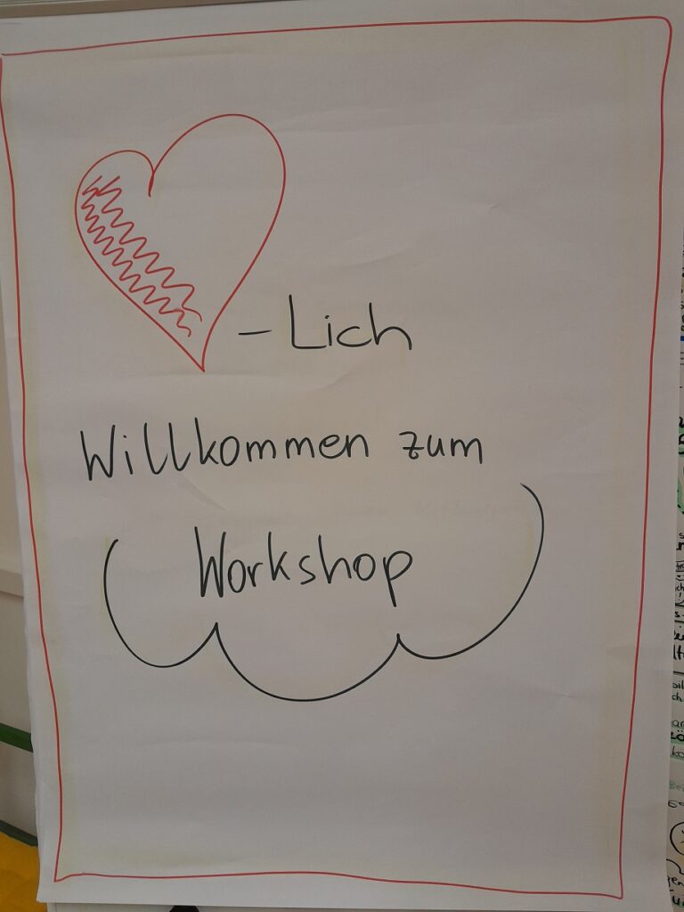 Foto eines Flipcharts. Darauf zu lesen ist: Herzlich Willkommen zum Workshop.