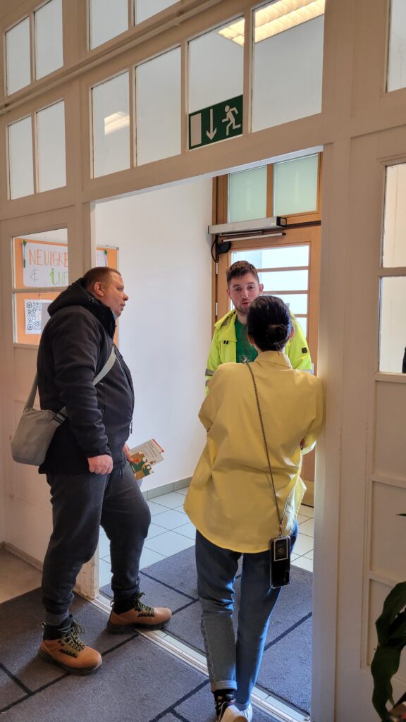 Drei Personen im Gespräch. Sie stehen im Eingangsbereich der Agentur Sonnenklar.