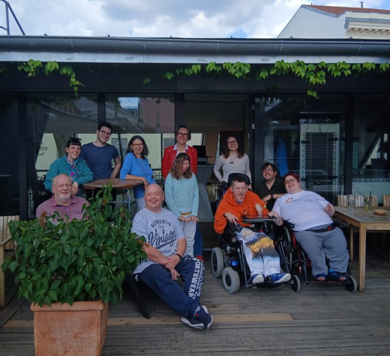Das Team der Agentur Sonnenklar Drehscheibe Peer Streitschlichtung bei der Klausur. Alle stehena uf einer Terasse und lachen in die Kamera.